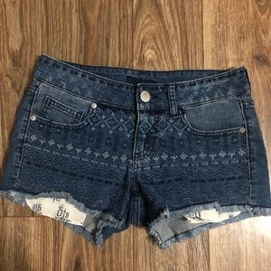 Jean shorts with a design on them.